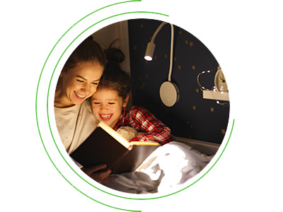 Mother reading a book to her child at night 