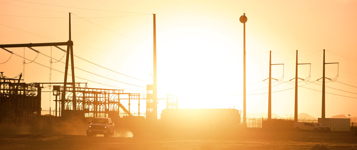 NextEra Energy transmission substation and power lines at sunrise.